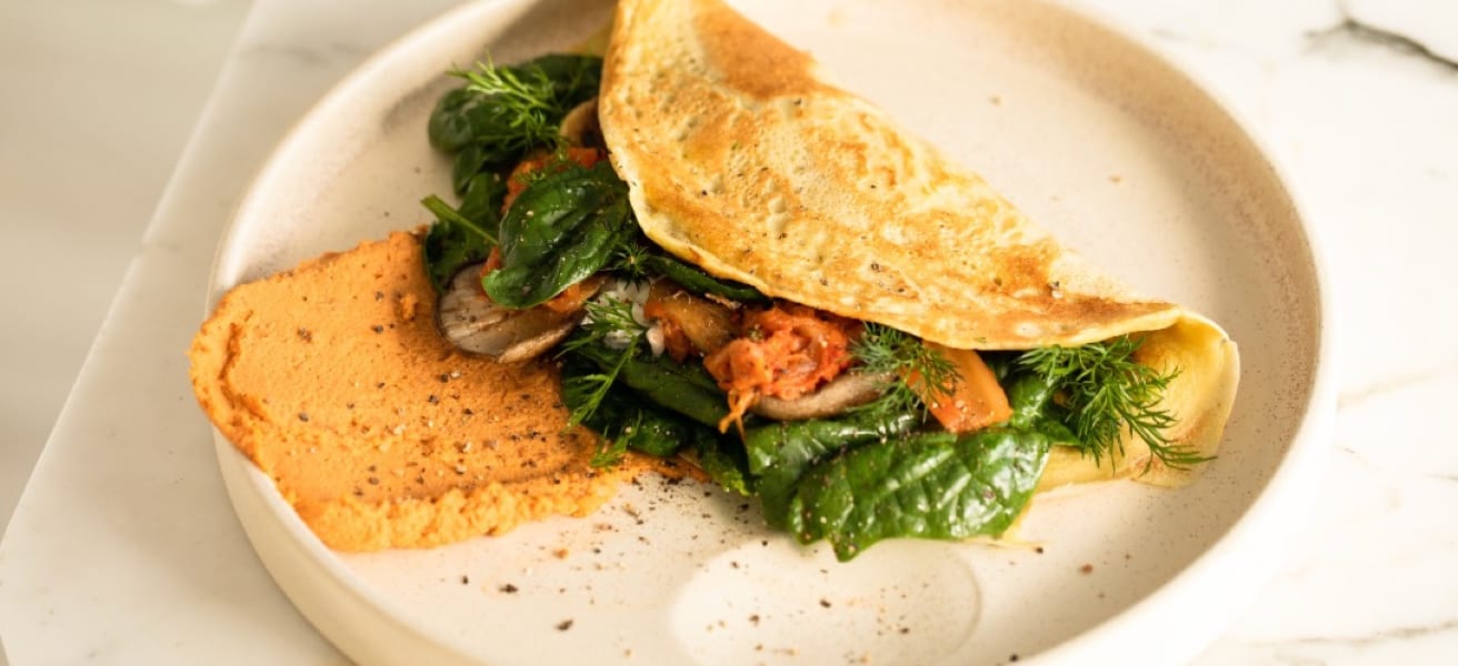Folded omelette with greens on a plate